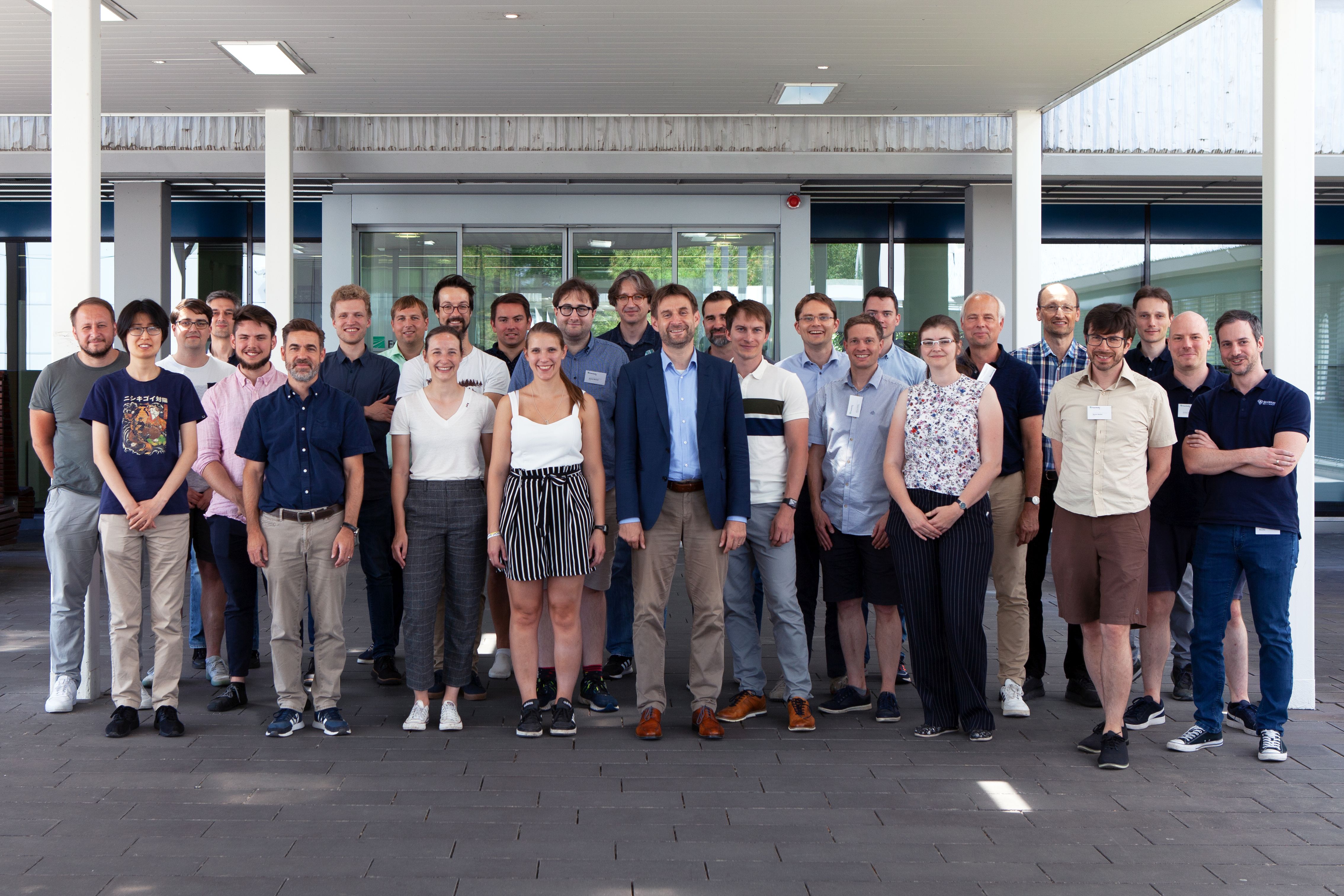 Gruppenfoto des SPINNING Projektkonsor: 36 Personen vor dem Haupteingang des Fraunhofer IAF.tium